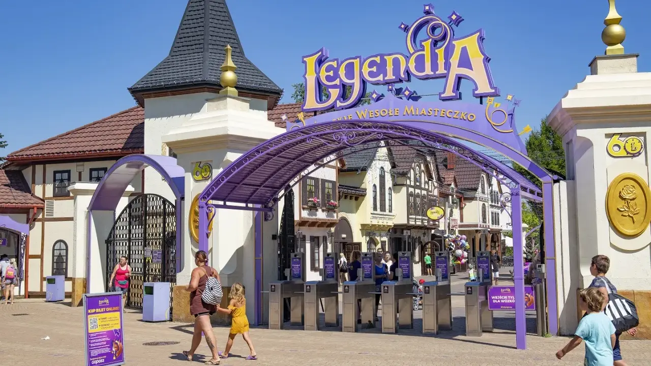 Wejście do Legendii, jednego z najpopularniejszych parków rozrywki w Polsce. Rodziny wchodzą przez bramki.