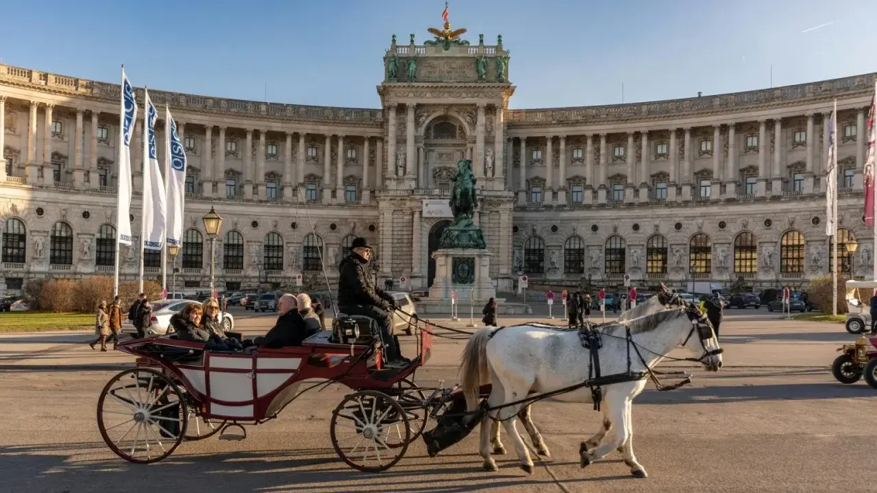 Wiedeń co zobaczyć: przejażdżka dorożką przed Hofburgiem, imponującym pałacem cesarskim.