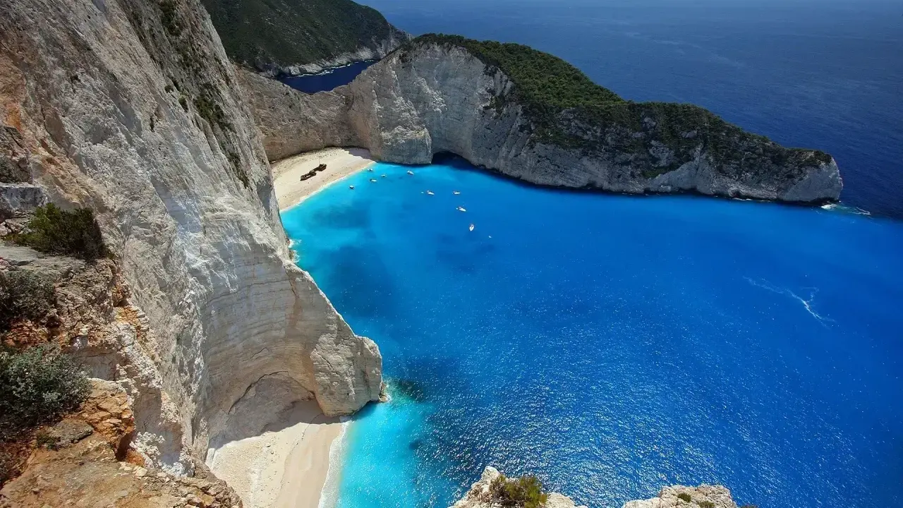Widok na zatokę wraku Zakynthos z klifu. Turkusowa woda, biała plaża i wrak statku.
