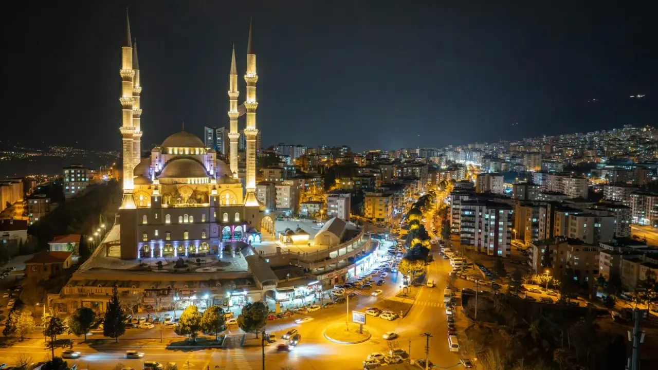 Piękny meczet nocą, oświetlony i otoczony miastem. Warto wiedzieć, ramadan co to za święty czas.