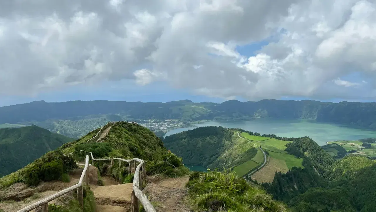Widok na jezioro Sete Cidades, Azory, Ponta Delgada. Ścieżka z barierkami prowadzi na szczyt z panoramą zielonych wzgórz i wody.