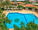 Basen hotelowy na Rodos, z leżakami i parasolami. Idealne miejsce na relaks pod słońcem.