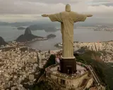 Majestatyczny pomnik Rio de Janeiro Jezus wita turystów, rozpościerając ramiona nad tętniącym życiem miastem i zatoką.