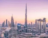 Dubaj o zachodzie słońca, z dominującym Burdż Chalifa, najwyższym budynkiem świata, otoczonym nowoczesnymi wieżowcami i autostradami.