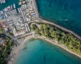 Widok z lotu ptaka na port i plażę w Kemerze. Widać liczne jachty i łodzie, a także zielony teren z drzewami. To idealne miejsce na odkrywanie atrakcji Kemer Turcja.