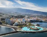 Puerto de la Cruz atrakcje: Lago Martianez, baseny z wodą morską, plaża, miasto i wulkan Teide w tle.