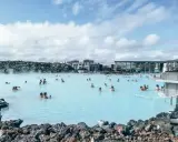 Relaks w Blue Lagoon Islandia. Ludzie kąpią się w mlecznoniebieskiej wodzie geotermalnej otoczonej wulkanicznymi skałami.