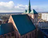 Gotycka katedra z zielonym dachem, otoczona miejską zabudową. Jedna z wielu atrakcji Pomorza Zachodniego.
