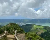 Widok na jezioro Sete Cidades, Azory, Ponta Delgada. Ścieżka z barierkami prowadzi na szczyt z panoramą zielonych wzgórz i wody.