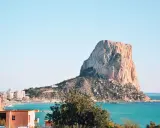 Imponujący klif Peñón de Ifach, jedna z głównych atrakcji Costa Blanca, góruje nad turkusowym morzem i nadmorskim miasteczkiem.