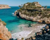 Malownicze wybrzeże z turkusową wodą i skalistymi klifami, idealne miejsce na wakacje na Palma de Mallorca.