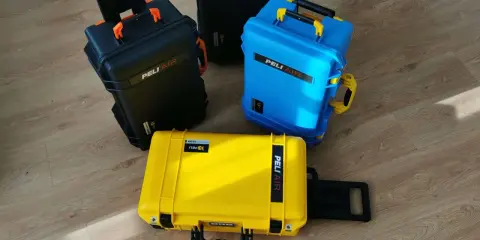 Trzy walizki Peli Air w kolorach czarnym, niebieskim i żółtym. Idealne do przewożenia cennego sprzętu w bagażu podręcznym.