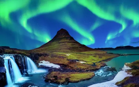Islandia najpiękniejsze miejsca: góra Kirkjufell i wodospad pod tańczącą zorzą polarną.