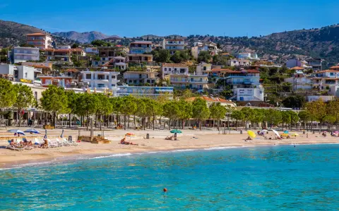 Albania, wrzesień, pogoda idealna na plażowanie. Słoneczny dzień, turkusowe morze i miasteczko na wzgórzu.