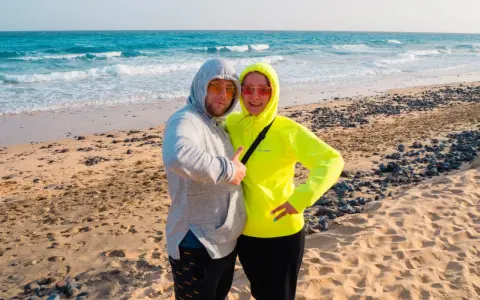 Para na plaży Fuerteventura w styczniu. Pogoda idealna na spacer brzegiem oceanu.