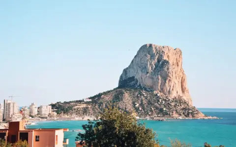 Imponujący klif Peñón de Ifach, jedna z głównych atrakcji Costa Blanca, góruje nad turkusowym morzem i nadmorskim miasteczkiem.