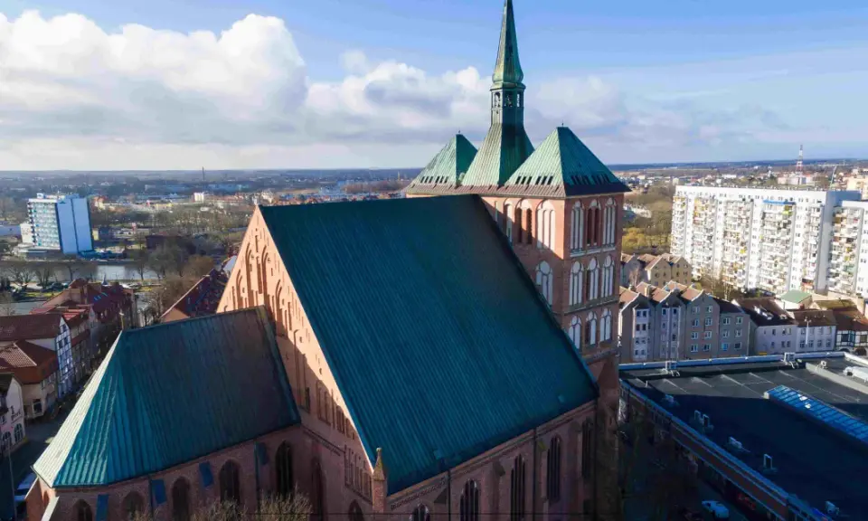 Gotycka katedra z zielonym dachem, otoczona miejską zabudową. Jedna z wielu atrakcji Pomorza Zachodniego.
