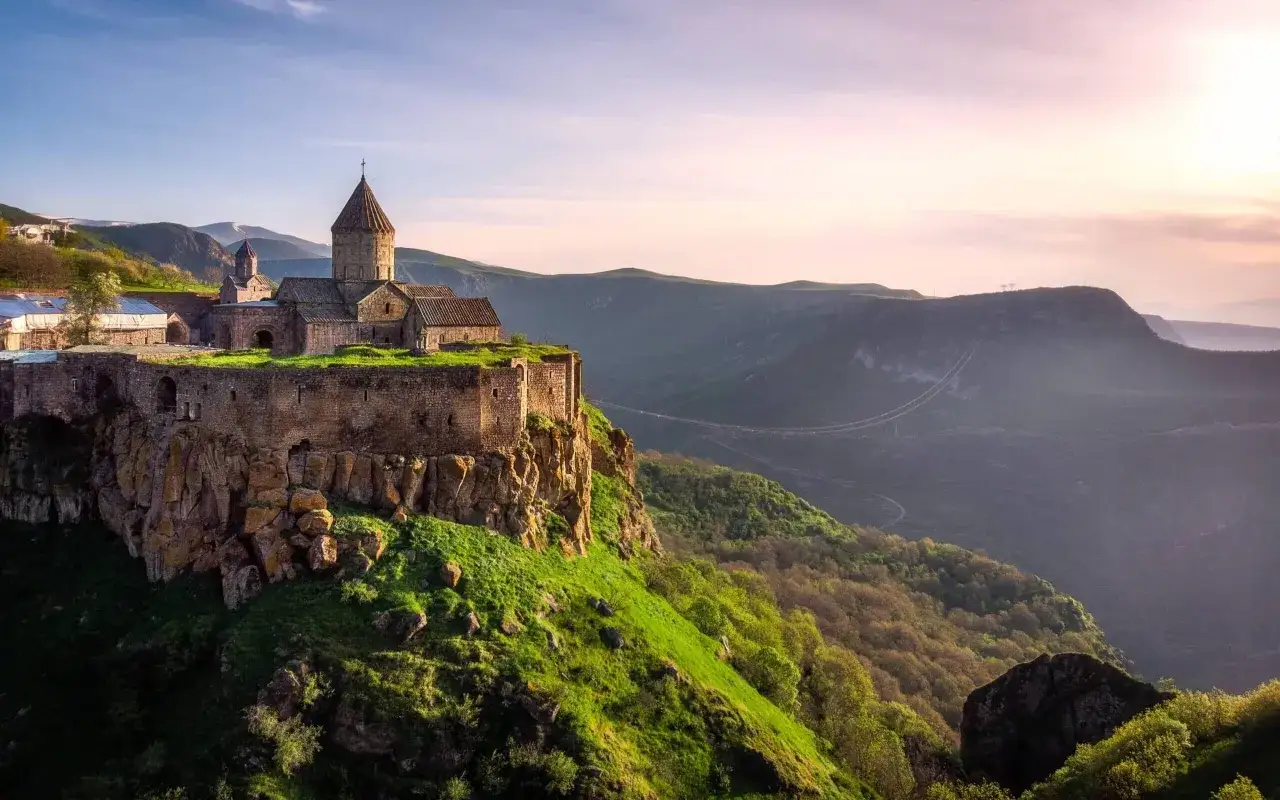 Klasztor Tatew na skale, wspaniały widok na Armenię co zobaczyć. Zielone wzgórza i góry w tle.