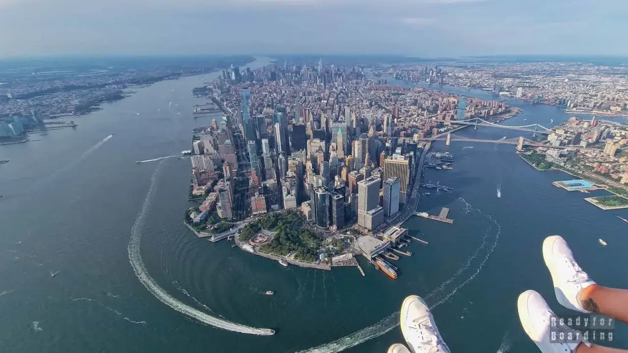 Widok na Manhattan z lotu ptaka, idealny, by zobaczyć, co zobaczyć w Nowym Jorku. Widać rzekę, mosty i mnóstwo drapaczy chmur.