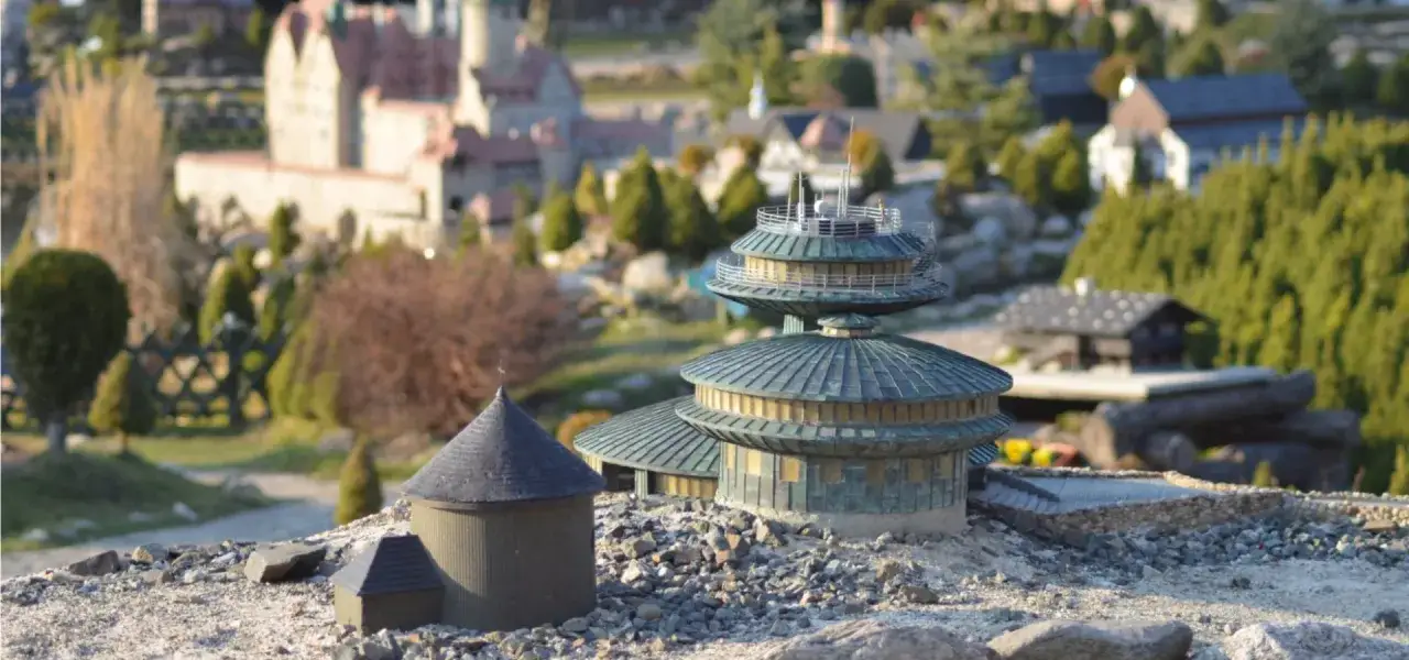 Miniaturowe budowle, jak zamek i nowoczesne wieże, tworzą krajobraz jednego z parków miniatur w Polsce.