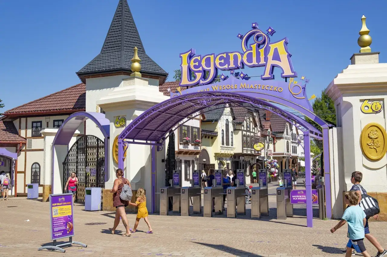 Wejście do Legendii, jednego z najpopularniejszych parków rozrywki w Polsce. Rodziny wchodzą przez bramki.