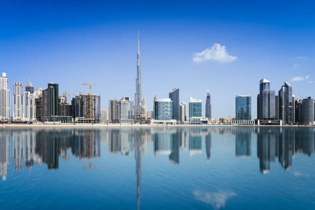 Dubaj, miasto marzeń, gdzie słynne budowle świata tworzą futurystyczny krajobraz odbijający się w spokojnej wodzie.