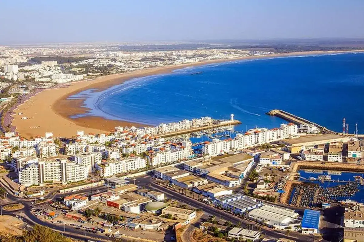 Agadir: zobacz szeroką plażę, białe budynki i port. Idealne miejsce na wakacje, gdzie warto zobaczyć zachód słońca nad oceanem.