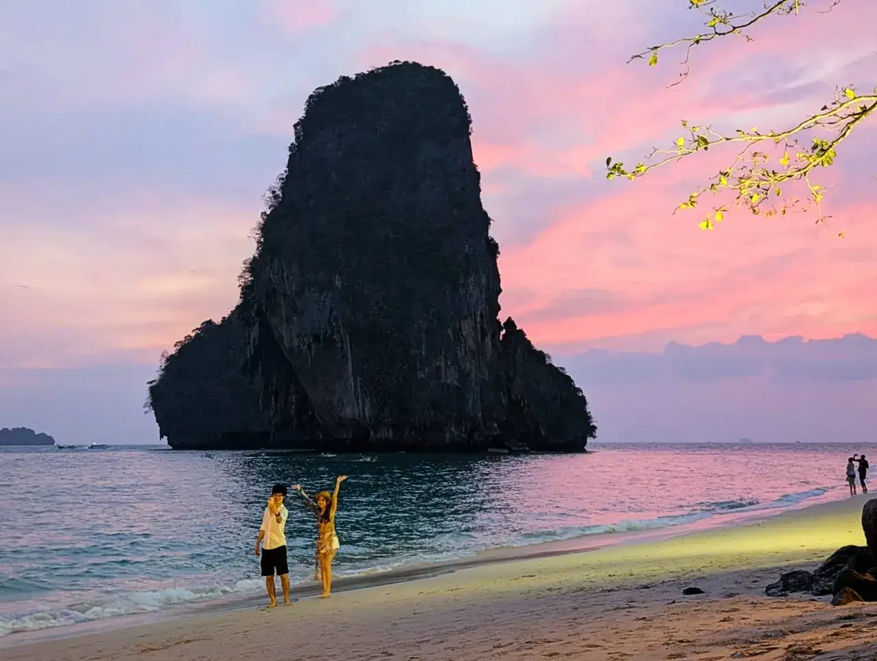 Zachód słońca w Krabi. Para spaceruje po plaży z widokiem na majestatyczną skałę. Krabi co zobaczyć to raj!